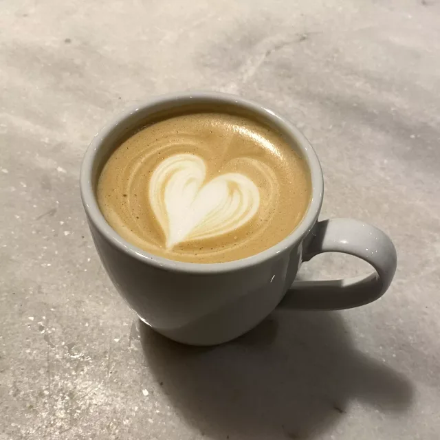 Capuchino con arte latte en forma de roseta