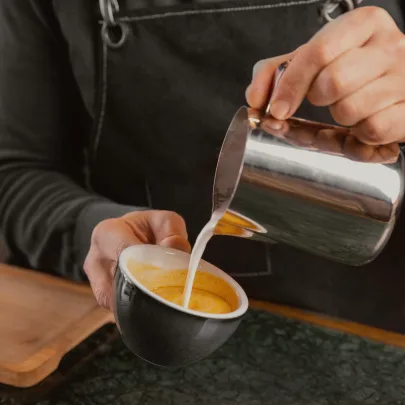 Barista preparando un café con leche texturizada